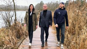 Wild-Wings-Geschäftsstellenleiterin Jenna Mamic, Villingen-Schwenningens OB Jürgen Roth und Wild-Wings-Stürmer Sebastian Uvira nebeneinander auf dem Steg unterwegs im Schwenninger Moos.