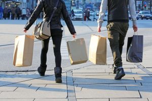 Zwei Personen tragen in jeder Hand Einkaufstüte